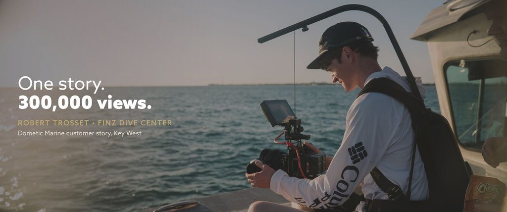Storyteller Studios cinematographer Eli Ommen films Dometic Marine’s customer story on the water in Key West, aboard Robert Trosset’s catamaran. Text over image: “One story. 300,000 views.” Robert Trosset, Finz Dive Center.