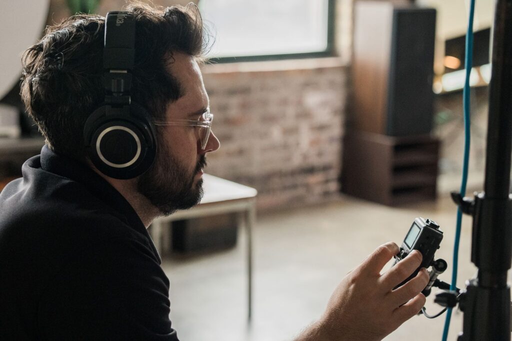 Storyteller Studios producer wearing headphones and monitoring audio during a documentary interview.