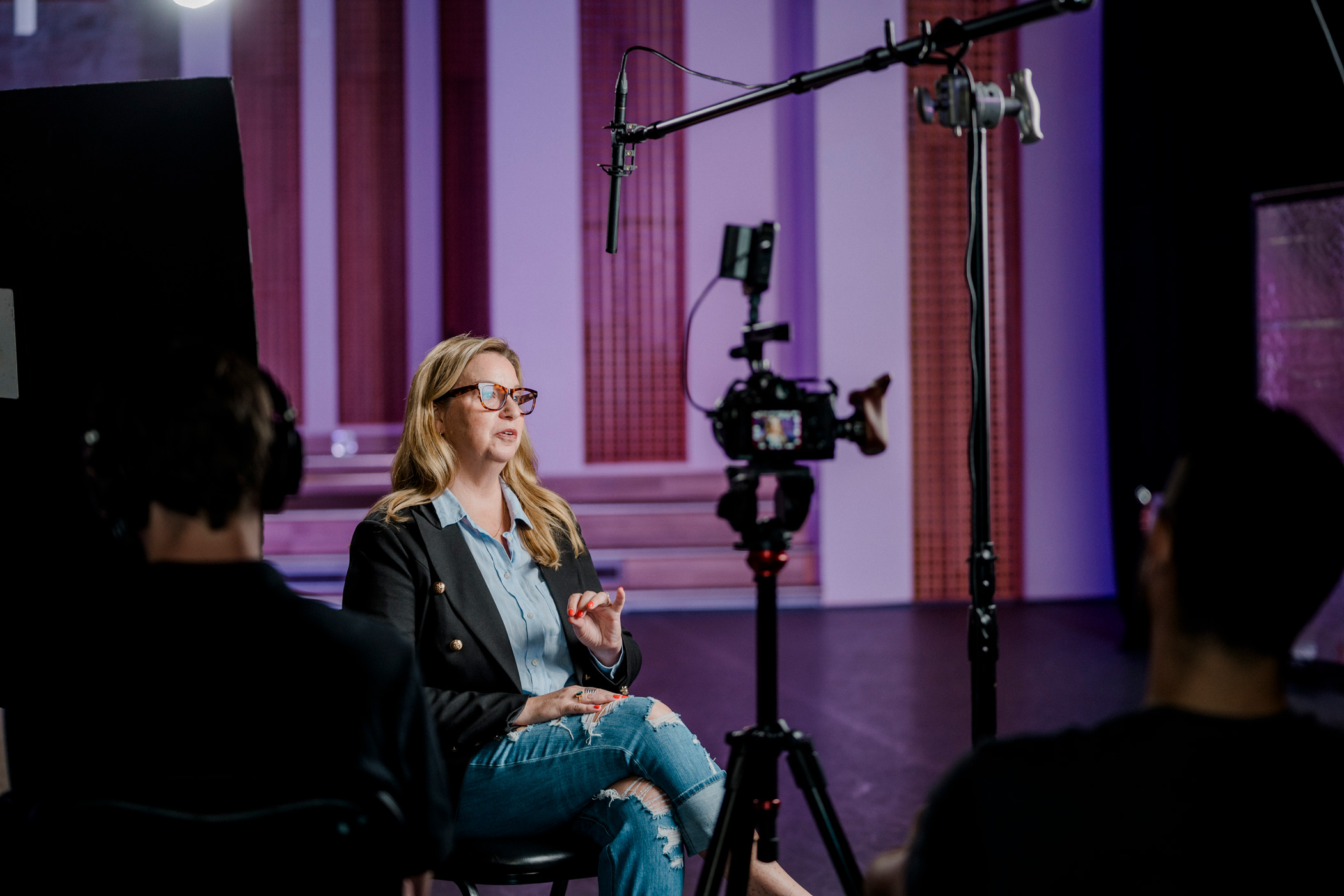 a woman earnestly discusses an important topic under lights and in front of cameras